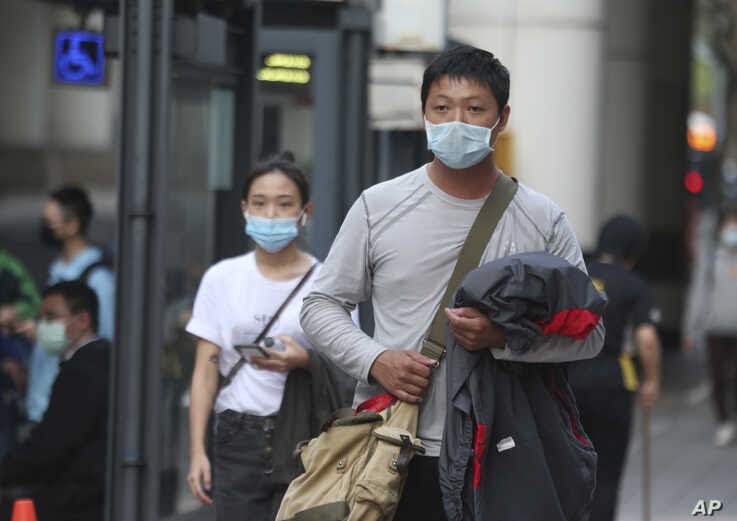 People wear face masks to protect against the coronavirus, in Taipei, Taiwan, Feb. 26, 2020. 